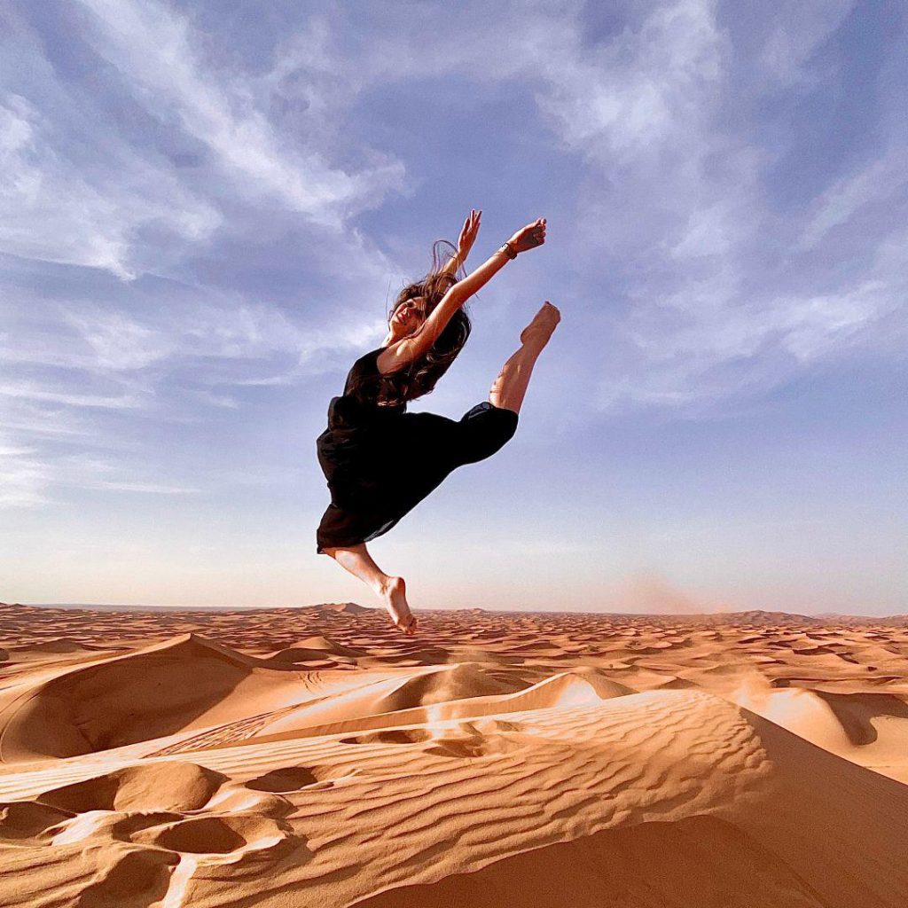 Girl jumping on the Desert and enjoying the Desert Safari in Abu Dhabi